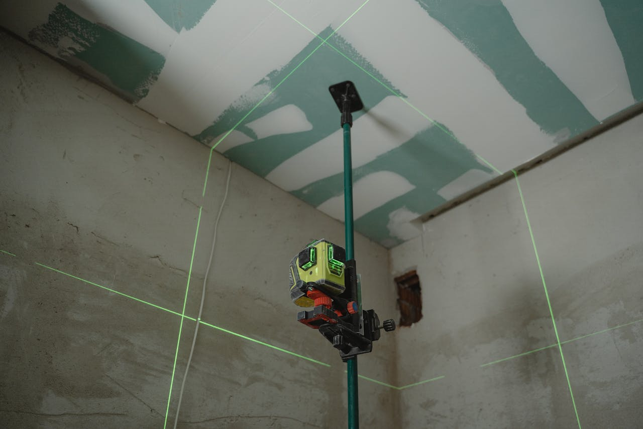 client-satisfaction-img A laser level tool in action at an indoor construction site with marked walls.